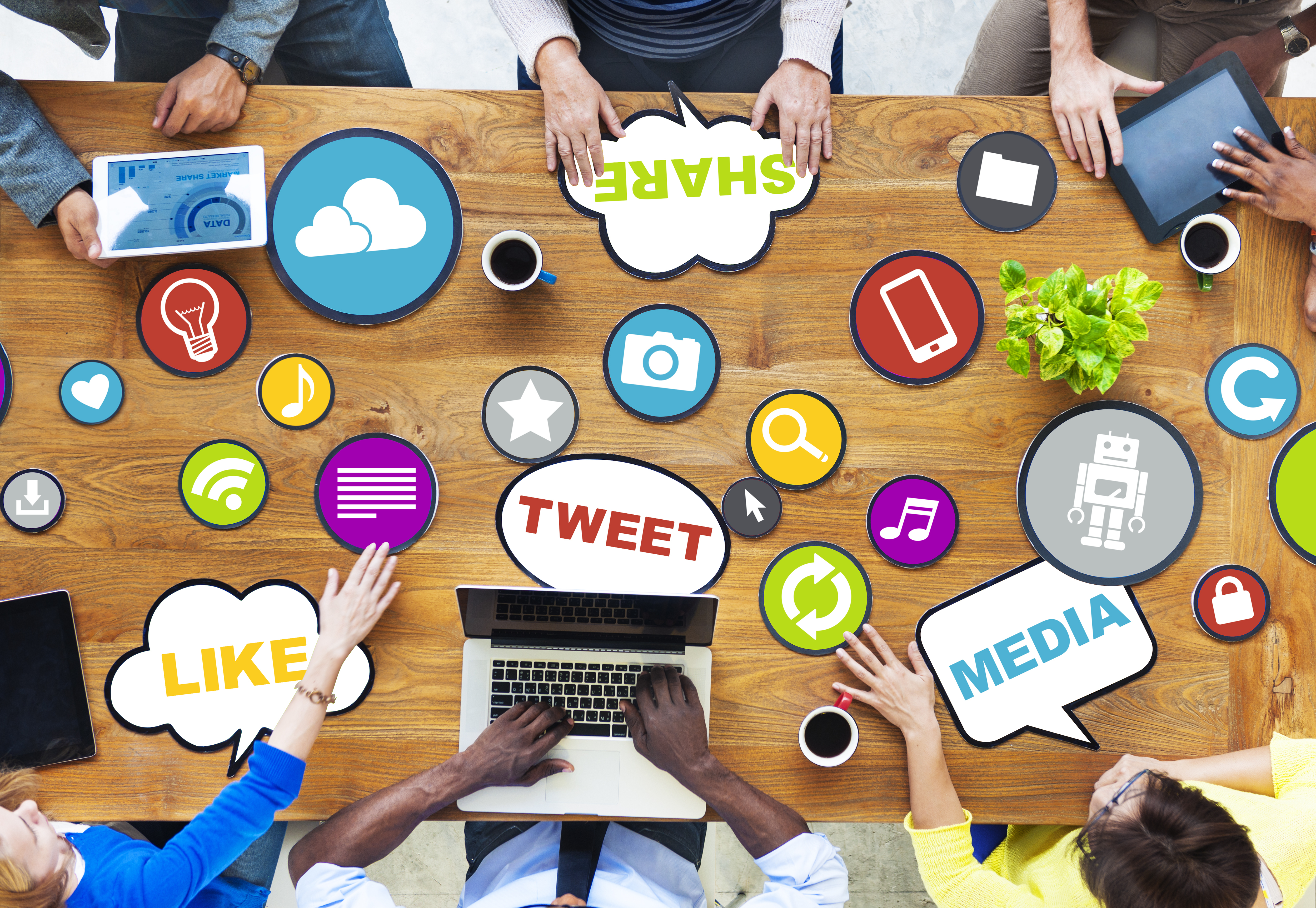 Table filled with tech devices, social media terms, and application icons.